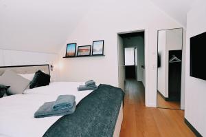 ホーヴァハトにあるDie-Strandburg-Moewenwegの白いベッドルーム(ベッド2台、鏡付)