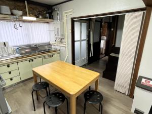a kitchen with a wooden table and some chairs at My STAGE in Asahikawa