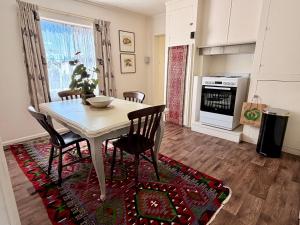a kitchen and dining room with a table and chairs at The Whitfield in Oamaru +51 photos