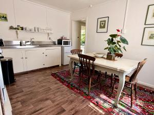 a kitchen with a table and chairs and a kitchen with white cabinets at The Whitfield in Oamaru