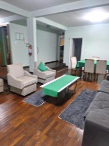 a living room with a couch and a table and chairs at Pousada Essenza lindoía in Águas de Lindóia