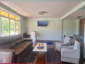 a living room with a couch and two chairs and a table at Pousada Essenza lindoía in Águas de Lindoia