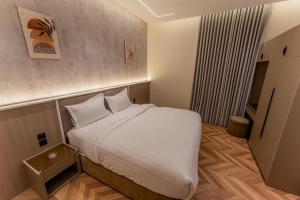 a small bedroom with a bed with white sheets at فندق نخبة العارض in Riyadh