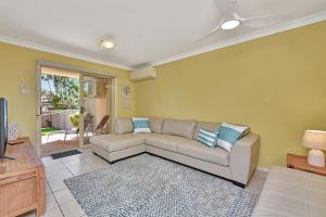 Una sala de estar con un sofá y un televisor. en Salt and Paws at Fingal Bay, en Fingal Bay