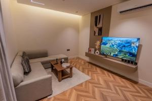 a living room with a couch and a flat screen tv at فندق نخبة العارض in Riyadh