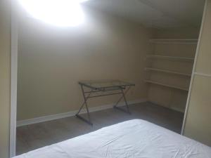 a room with a bed and a table and shelves at Cozy Comfort in Brampton