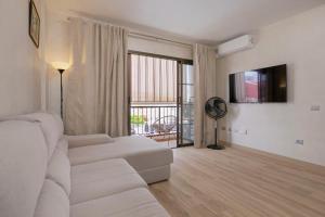 a living room with a white couch and a large window at Cozy apartment in classic style in Playa de San Juan