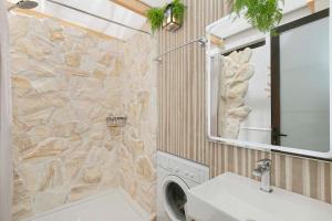 a bathroom with a sink and a stone wall at Cozy apartment in classic style in Playa de San Juan +26 photos