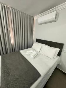 a bedroom with a bed with two towels on it at Apartamento 1011 in Goiânia +17 photos