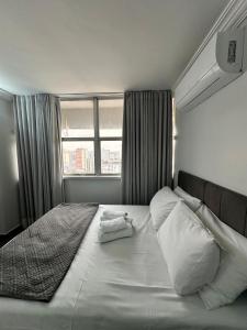 a bedroom with a large bed with pillows and a window at Apartamento 1011 in Goiânia