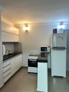 a kitchen with white appliances and a white refrigerator at Apartamento 1011 in Goiânia