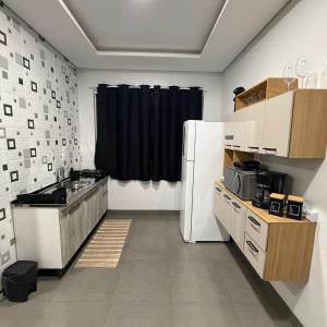 a kitchen with a white refrigerator and a black curtain at VivaVida Imperial 103 in Sinop