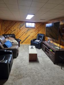 a living room with two couches and a flat screen tv at Cozy Hideaway in Lewiston
