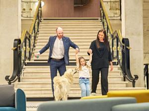a woman and a man and a child walking a dog at Novotel Rouen Centre Cathédrale in Rouen