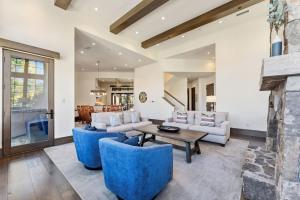ein Wohnzimmer mit blauen Stühlen und einem Kamin in der Unterkunft West Vail Retreat Steps to Ski plus Private Hot Tub in Vail
