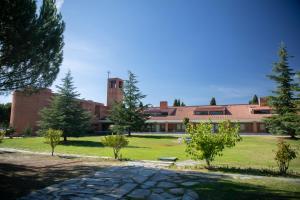 a large brick building with a clock tower in a park at Alojamiento cristo rey in Pozuelo de Alarcón