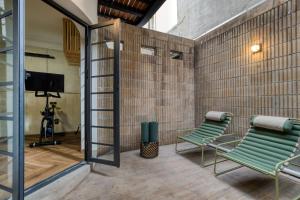 a room with two green chairs and a tv at Rodona Hotel in Mexico City