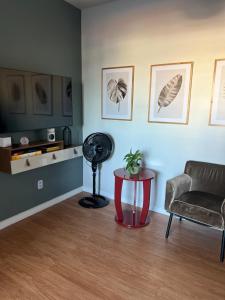 a living room with a chair and a table at APTO 401 - no centro, pertinho de tudo in Poços de Caldas