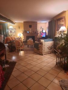 a living room with a couch and a tv at Les bosquets chambre d hôtes in Caugé