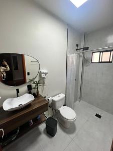 a bathroom with a sink and a toilet and a mirror at APTO 401 - no centro, pertinho de tudo in Poços de Caldas +17 photos
