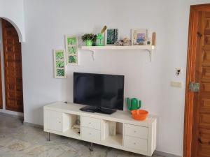 a white entertainment center with a television on a wall at Paraíso Veracoast in Vera
