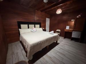 a bedroom with a large bed in a room with wooden walls at Hotelito Villas Holbox in Holbox Island +25 photos