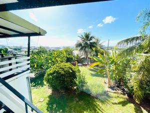 a view from the balcony of a house with palm trees at Hotu's Bungalow in Papeete