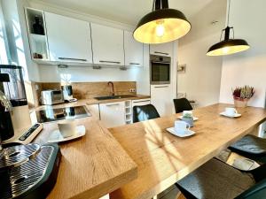 a kitchen with a large wooden table with chairs at Whg Dynamique in Zingst