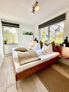 a large bed in a room with windows at Whg Dynamique in Zingst