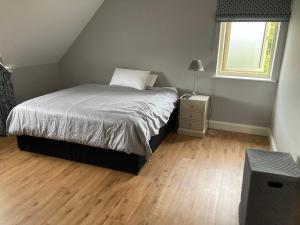 a bedroom with a bed and a night stand and a window at Circular Road Comfort - UHG & University Access in Galway