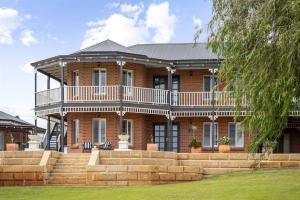 Cette grande maison en briques dispose d'un balcon et d'un escalier. dans l'établissement De'Vinceant - The Grand Manor by Wonnerup Beach, à Geographe