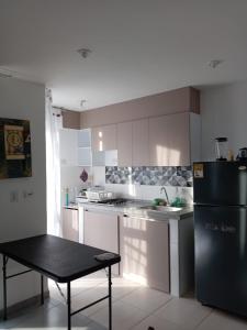 a kitchen with a black refrigerator and a table in it at Condomio Alicante Bahia Solero in Ricaurte