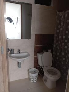 a bathroom with a toilet and a sink and a mirror at Condomio Alicante Bahia Solero in Ricaurte +4 photos