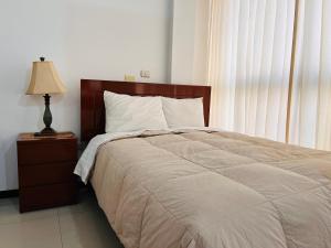 Un dormitorio con una cama y una lámpara en una mesita de noche. en MiniDepartamento Plaza de Armas, en Puno