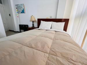 Un dormitorio con una cama grande con un edredón grande. en MiniDepartamento Plaza de Armas, en Puno