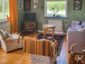 a living room with a couch and a table at Cozy Getaway near Forest and Lake in Insjön