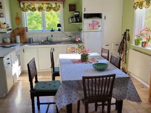 a kitchen with a table and chairs and a kitchen with a refrigerator at Cozy Getaway near Forest and Lake in Insjön +17 photos