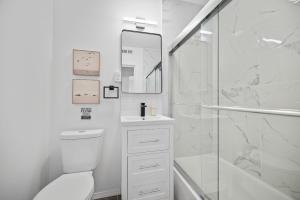 a white bathroom with a toilet and a shower at Pittsburgh Shadyside 3D Cozy and Stylish Private Bedroom with Shared Bathroom in Pittsburgh