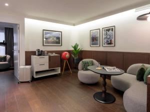 a living room with a couch and a table at Le Louise Hotel Brussels - MGallery Collection in Brussels