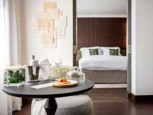 a room with a table with a plate of fruit on it at Le Louise Hotel Brussels - MGallery Collection in Brussels +103 photos