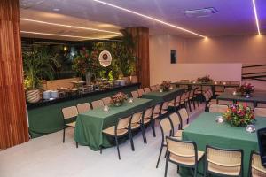 a banquet hall with green tables and chairs at Amazon Park Hotel in Belém