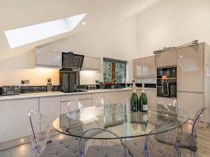 a kitchen with a glass table and chairs in it at Waterside Lodge in Elland