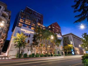 トビリシにあるTbilisi Philharmonic Hotel by Mercureの高層ビルが立ち並ぶ夜の街道 +117枚の写真