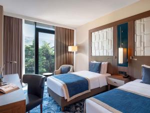 a hotel room with two beds and a desk at Tbilisi Philharmonic Hotel by Mercure in Tbilisi City +162 photos
