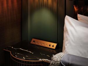 a room with a bed and a table with a pillow at Hotel Sosei Sapporo MGallery Collection in Sapporo