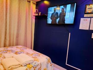 Cette chambre dispose d'une télévision et d'un lit avec des serviettes. dans l'établissement Casa Lilia Airport, à Panama City