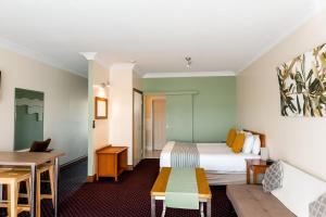 a hotel room with a bed and a table at The Henry Parkes Tenterfield in Tenterfield