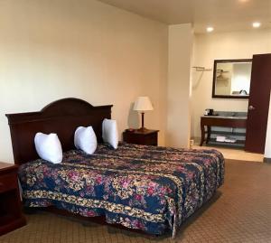 a hotel room with a bed and a mirror at HiWay Inn Express in Coalgate