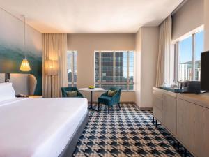 a hotel room with a bed and a table at Pullman Cape Town City Centre in Cape Town