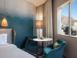 a hotel room with a bed and a table and chairs at Pullman Cape Town City Centre in Cape Town +162 photos